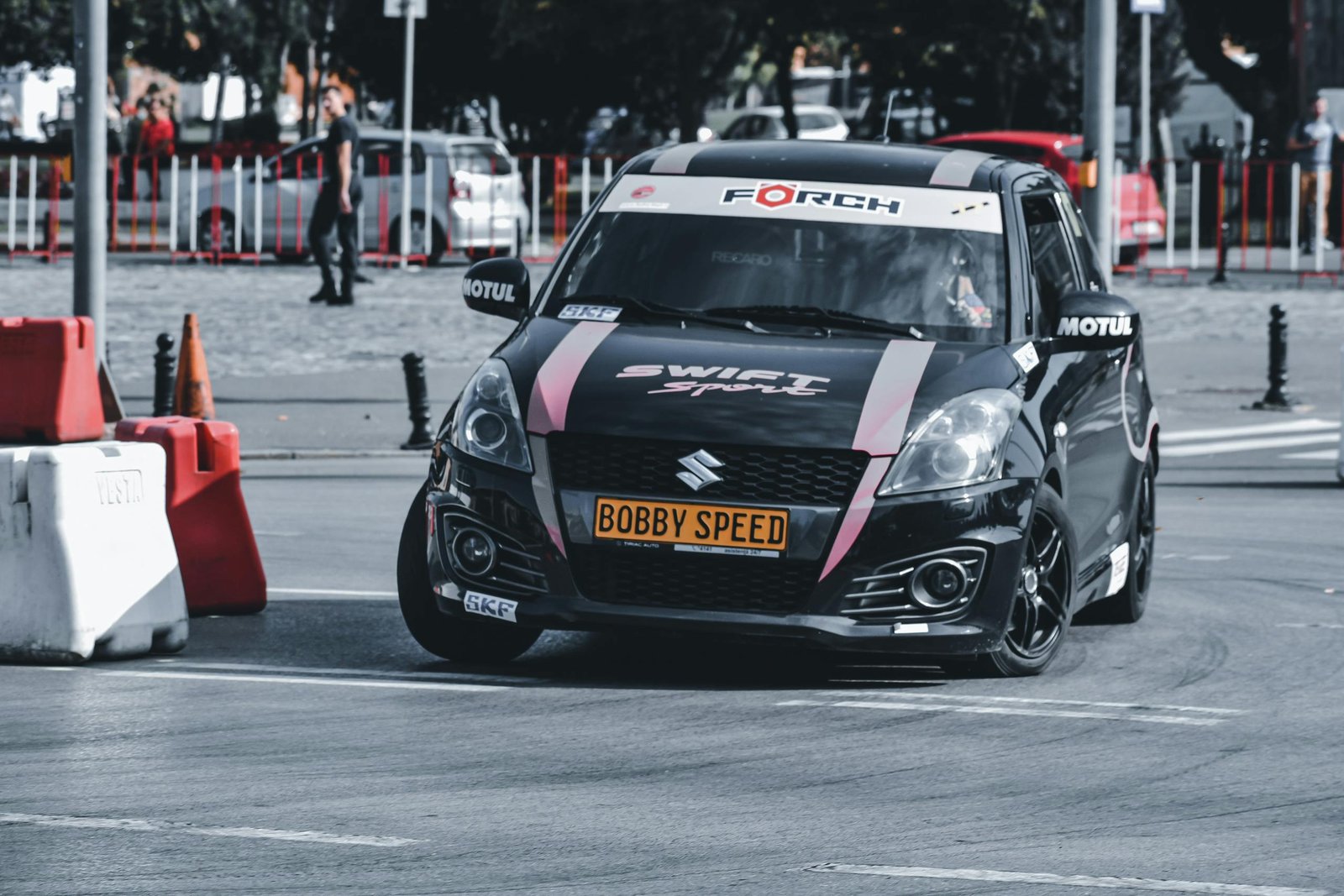 Dynamic shot of a racing car maneuvering on an urban track.